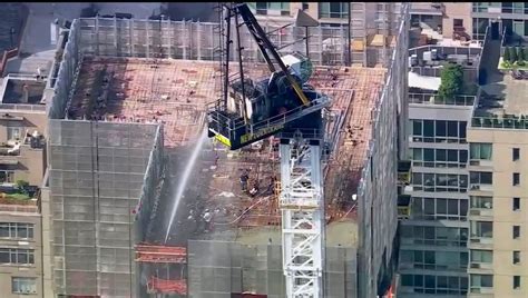 New York construction crane catches fire, and its arm hits skyscraper as it crashes to street